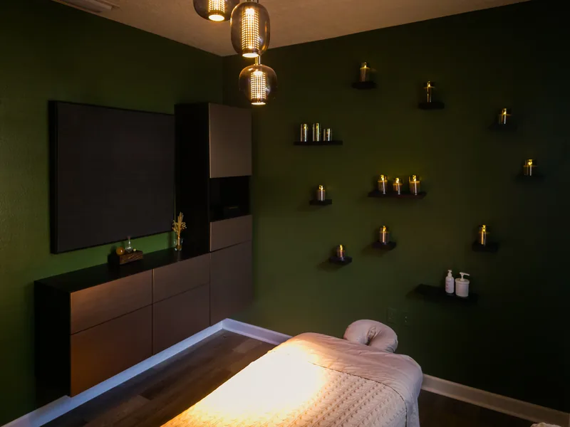 The private treatment room at Hands by Huan, with a massage table and a dark green wall